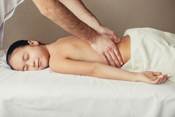 Wall Mural - masseur does massage to the little smiled girl