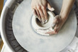 Ceramic working process with clay potter's wheel, close-up of woman hands