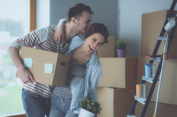 Happy young couple unpacking or packing boxes and moving into a new home