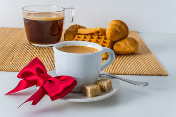 Fresh croissants and delicious waffles with two coffee on bamboo mat, bakery