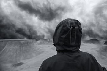 Wall Mural - Unrecognizable hooded person in empty skateboarding park