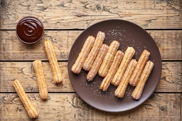 Wall Mural - traditional churros spanish homemade sweet dessert pastry food on vintage wooden table background