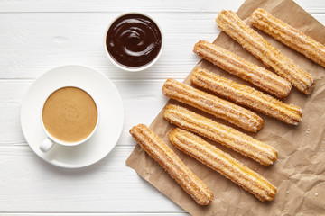 Wall Mural - churros traditional spain street fast food baked sweet dough snack with chocolate and coffee, rustic