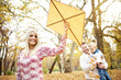 © chika_milan - Family day in the park, mother holds kite