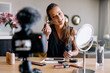 Young female vlogger recording a make-up broadcast.
