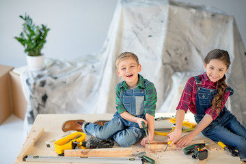 Wall Mural - Kids sawing wooden plank