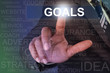 © flowgics - Businessman touching goals button on virtual screen