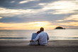 © Panot - Couple watching sunset in the beach romantic scene