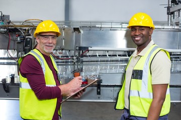 Portrait of two factory workers with clipboard 