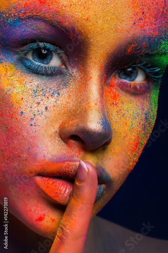 Model with art make-up posing on dark background