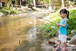 Leinwandbild Motiv Happy Asian Chinese little girl angling with fishing rod