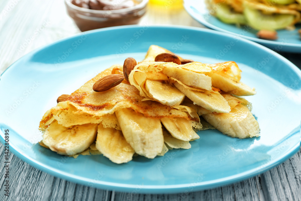 Blue plate with delicious pancakes on wooden table