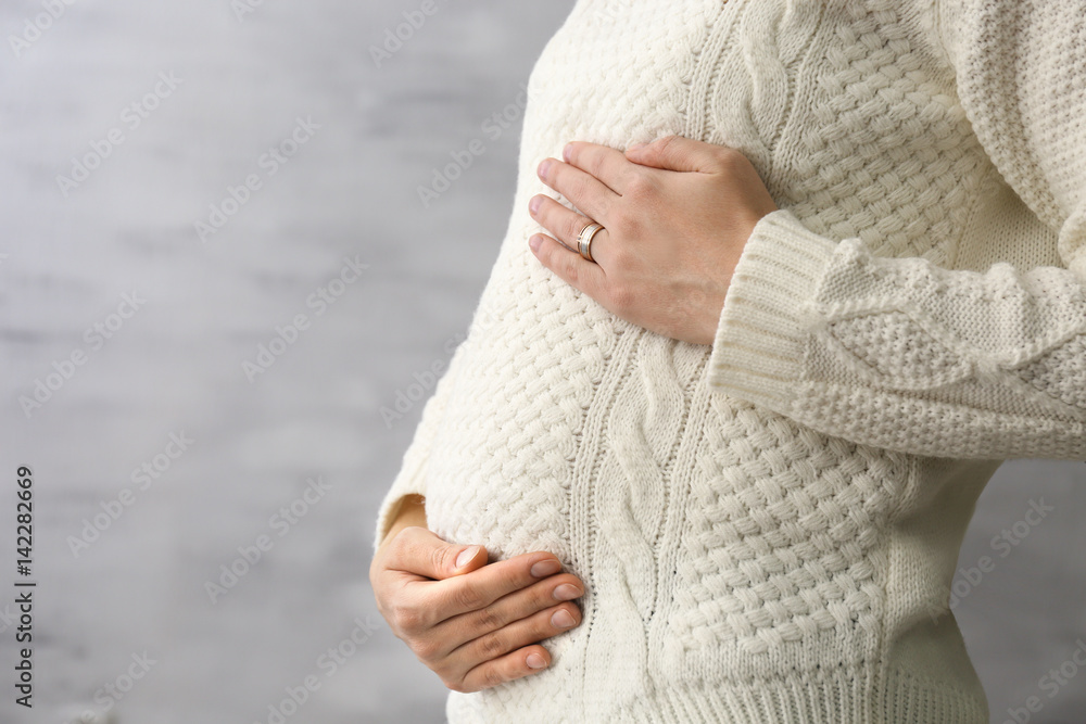 Beautiful pregnant woman on blurred background, closeup