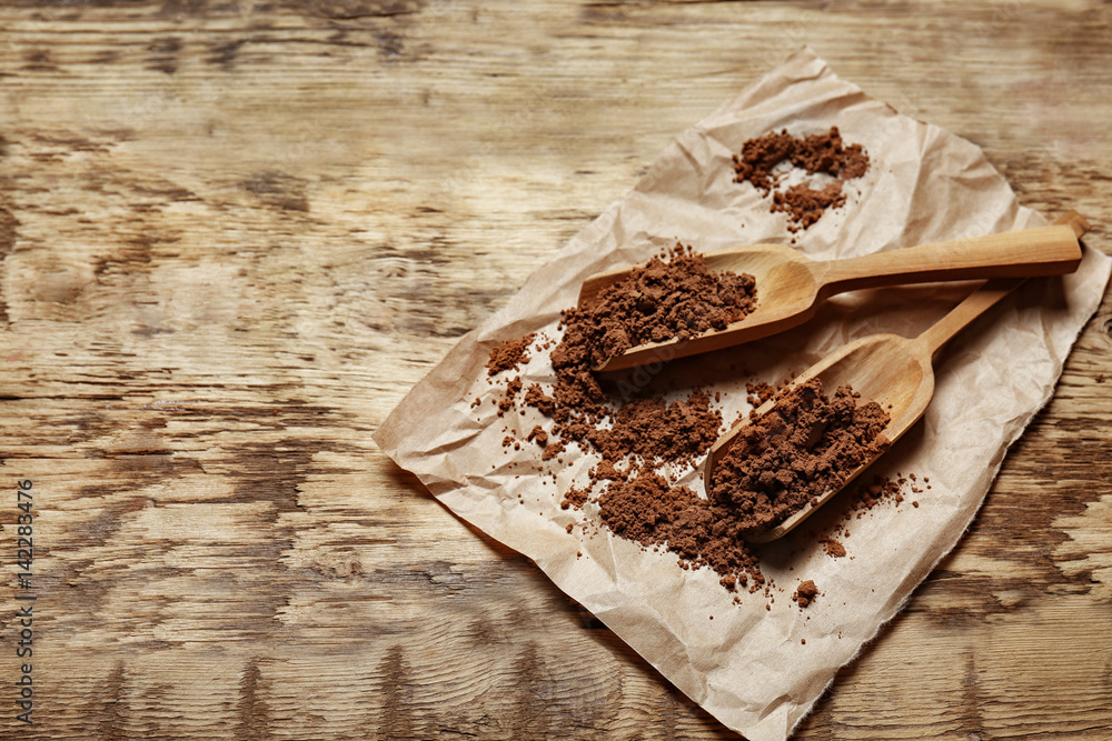 Wooden spoons with cocoa powder on paper napkin