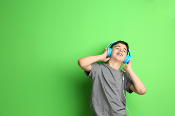 Poster - Teenager with headphones listening to music on color background