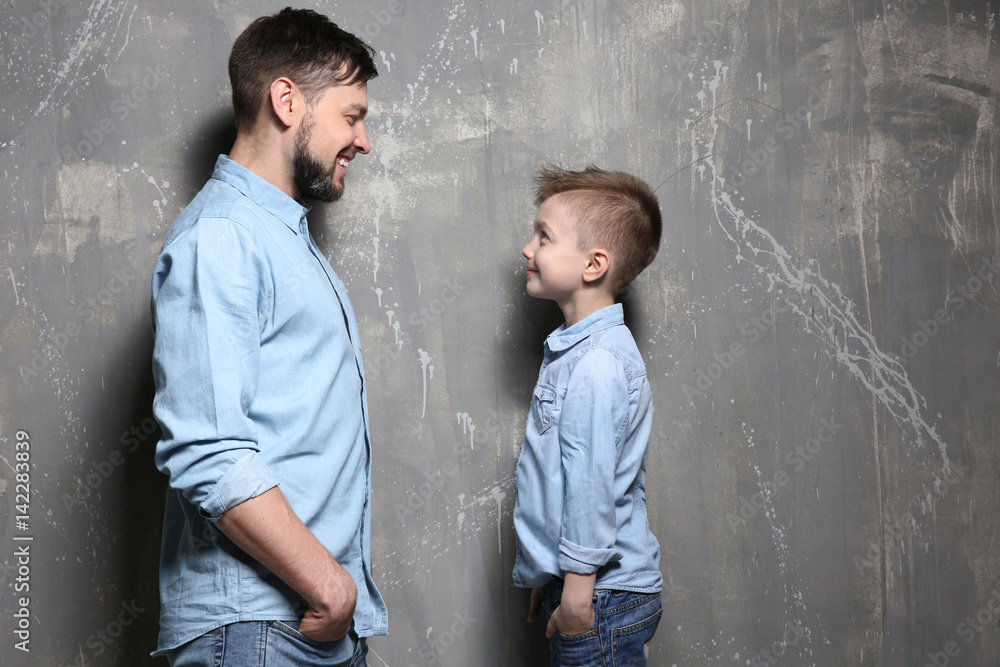 Handsome man with his son near grunge wall