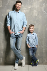 Wall Mural - Handsome man with his son near grunge wall