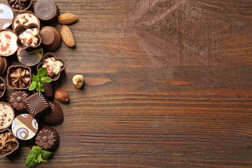 Canvas Print - Delicious chocolate candies on wooden background