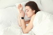 © Africa Studio - Young woman with sleep tracker resting in bed at home