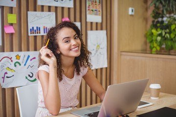 Wall Mural - Portrait of female graphic designer using laptop