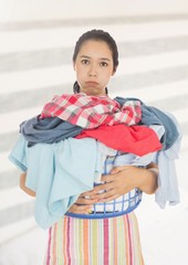 Wall Mural - Tired upset woman with laundry basket against bright background