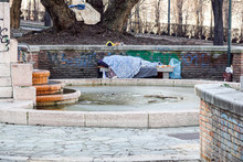 Homeless Man Sleeping Peacefully On Wooden Bench