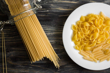 Raw pasta on a wooden table. Different types of pasta.