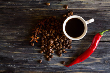 A cup of black coffee and chili on a wooden table