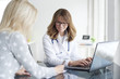 © sepy - Doctor and her patient. Shot of a middle aged female doctor sitting in front of laptop and consulting with her patient.