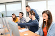 © W PRODUCTION - group of young people with desktop computer in row and headset training with teacher instructor in customer service call support helpline business center