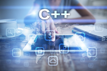 Woman using tablet pc, pressing on virtual screen and selecting c++.