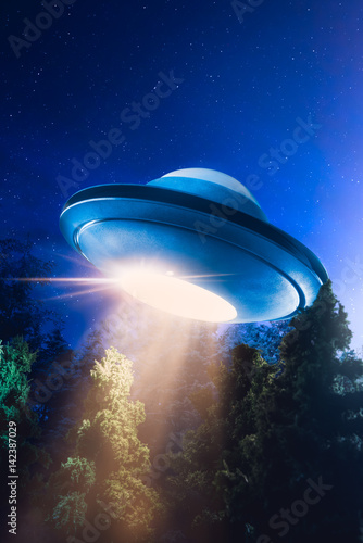 Plakat Wysoki kontrast obrazu UFO lecący nad lasem z wiązki światła w nocy