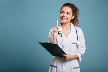 Portrait Of A Thoughtful Female Doctor Or Nurse Holding Clipboard