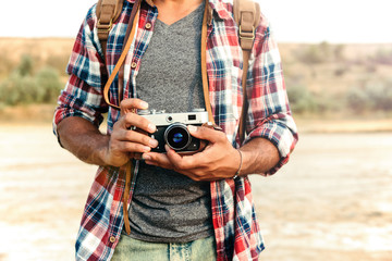 Man in plaid shirt holding old vintage photo camera