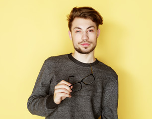 Poster -  Young  trendy man with glasses smiling, studio shot