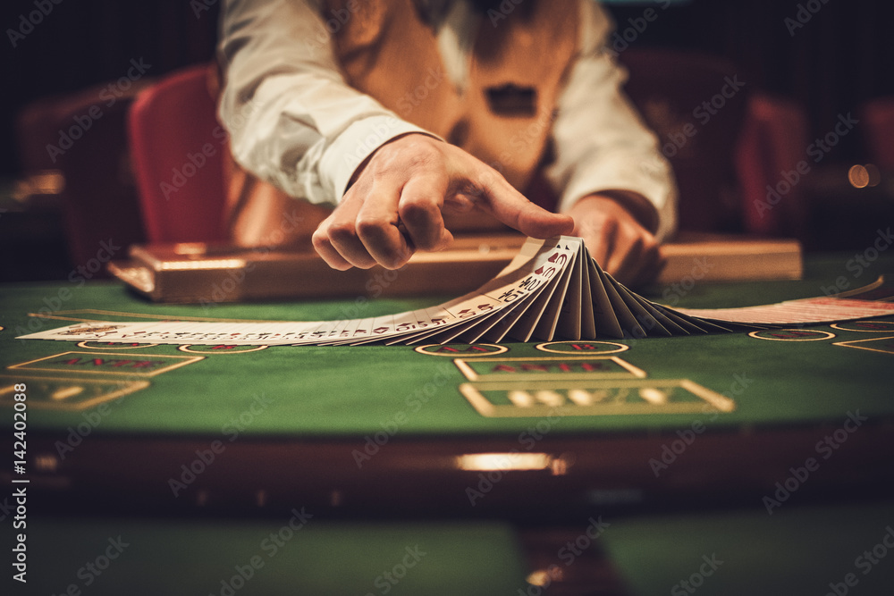 Croupier behind gambling table in a casino - obrazy, fototapety, plakaty 