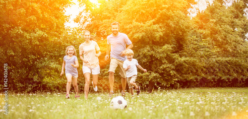 Plakat Rodzina z piłką gra w piłkę nożną w lecie