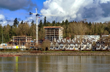 Wall Mural - Construction of a new high-rise buildings in the city side of the riverbank in city of Vancouver