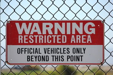 Restricted Area Sign On Metal Fence