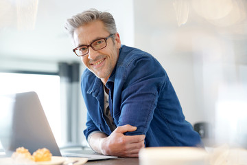 Handsome 45-year-old man at home connected on laptop