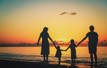 Wall Mural - happy family with two kids walking at sunset