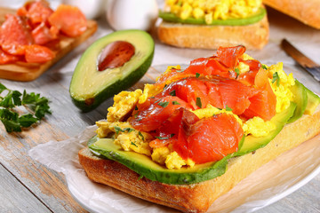 Wall Mural - sandwich with salmon, avocado, scrambled eggs