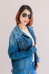 Asian woman casual outfits standing in jeans and blue denim shirt, women brown hair and short hair, smiling and wearing jeans jacket, beauty and fashion Jeans concept, space wall background