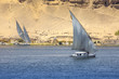 Felucca (river boat) on the Nile, with the Sahara behind in Aswan, Egipt.