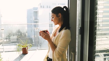 Wall Mural - Woman relaxing on balcony holding cup , drinking coffee or tea