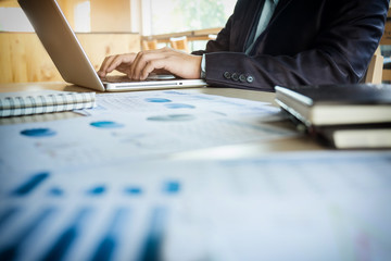 Wall Mural - Young business manager working at office with laptop and financial data documents on his desk.