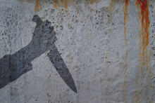 Human Hand With Killing Knife Silhouette In Shadow On Concrete Wall And Blood Background, With Space For Text Or Image.