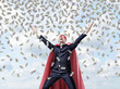 © gearstd - A smiling businessman in a superhero red cape with hands raised in success motion under money waterfall.