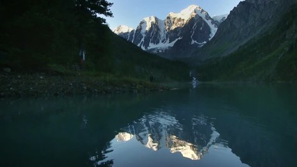 Wall Mural - The top of the mountain are covered with glaciers flowing down to the rocky slope. Altai, the North-Chuya ridge - Highlands region of Siberia. Lake Shavla and peaks reflecting in the water
