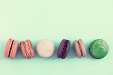 Raw Of Pastel Colors Assorted French  Macaroons On A Vintage Toned Bluebackground.  Copy Space For Text